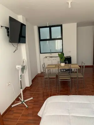 a bedroom with a bed and a table and chairs at Minidepartamentos Amoblado I en Estreno in Ica