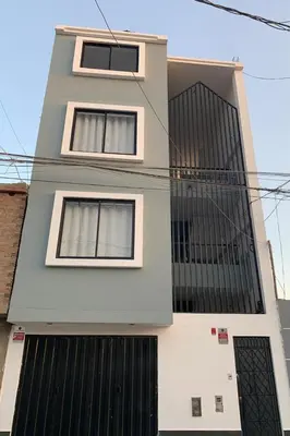 a building with three windows and black shutters at Minidepartamentos Amoblado I en Estreno in Ica