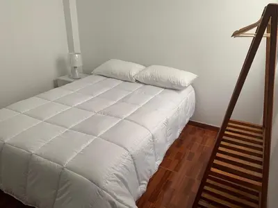a bedroom with a white bed and a staircase at Minidepartamentos Amoblado III en Estreno in Ica
