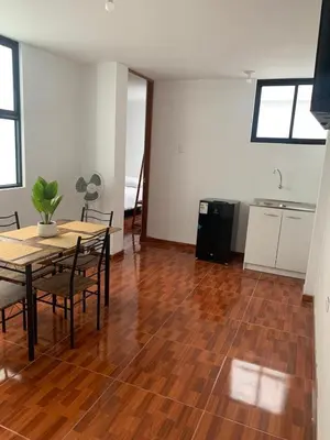 a room with a table and chairs and a kitchen at Minidepartamentos Amoblado III en Estreno in Ica