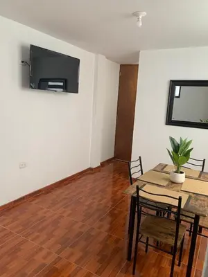 a dining room with a table and a television on the wall at Minidepartamentos Amoblado III en Estreno in Ica