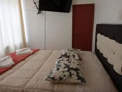 a bed with a pillow on it in a bedroom at Apartamento familiar 9 personas tranporte incluido in Cusco