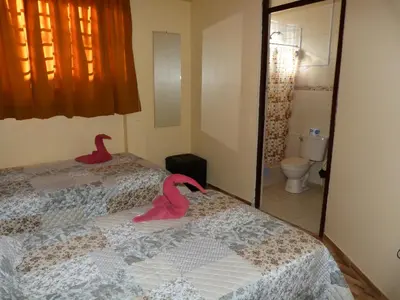 a bedroom with two pink swans on the bed at Matryoshka in Ica