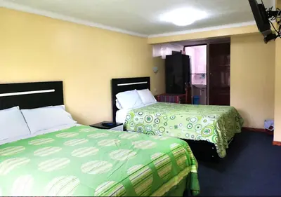a hotel room with two beds and a window at Hostal Lucerito in Cusco