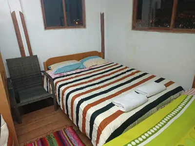 a bed with a striped blanket in a room at San Blas House in Cusco