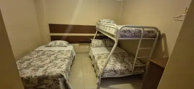 a small room with two beds and a bunk bed at Hospedaje Valencia in Ica