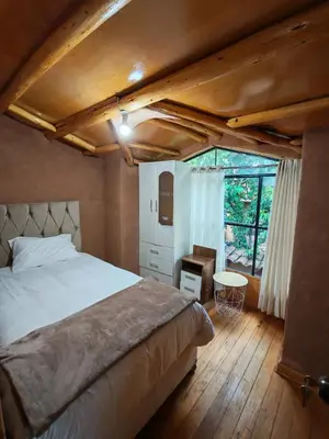 a bedroom with a bed and a large window at Condominio Villa Andina in Urubamba