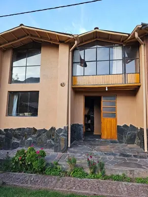 a house with a wooden door and windows at Condominio Villa Andina in Urubamba