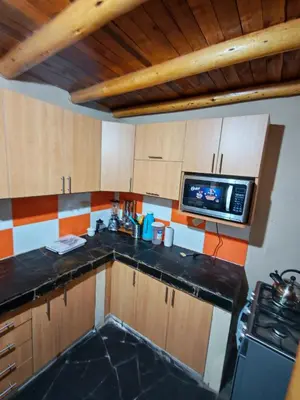 a small kitchen with a sink and a microwave at Condominio Villa Andina in Urubamba