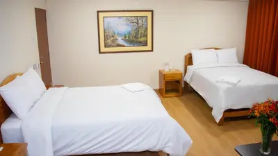 a hotel room with two beds and a picture on the wall at Hotel Centro Huancayo in Huancayo