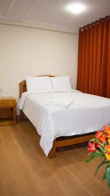 a bedroom with a large bed with a wooden headboard at Hotel Centro Huancayo in Huancayo