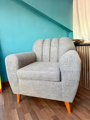 a gray chair in a room with a blue wall at Rustic House in the Heart of Cusco in Cusco