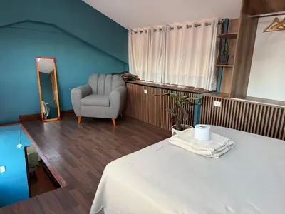 a room with a bed and a chair and a window at Rustic House in the Heart of Cusco in Cusco