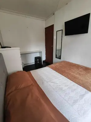 a bedroom with a large bed and a flat screen tv at Habitación acogedora cerca a Larcomar in Lima