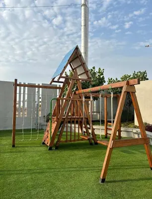 a wooden swing set on the grass in a park at Come and have fun with the family in San Bartolo