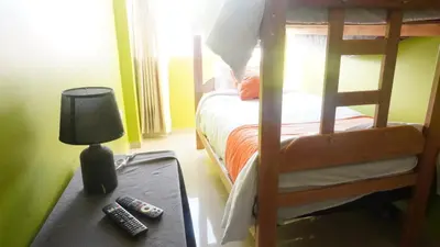 a bedroom with a bunk bed with a lamp and remote controls at BR Comfortable Stay Inn in Cusco