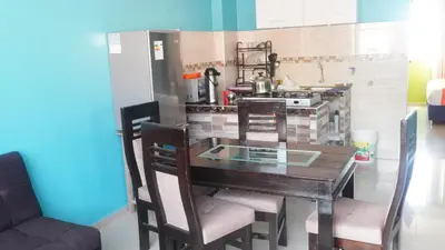 a kitchen with a wooden table with chairs and a stove at BR Comfortable Stay Inn in Cusco