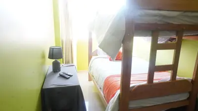 a bedroom with two bunk beds and a table with a lamp at BR Comfortable Stay Inn in Cusco