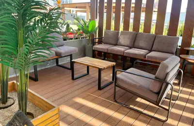 a patio with a couch and a table and a plant at Duplex con piscina en Miraflores in Lima