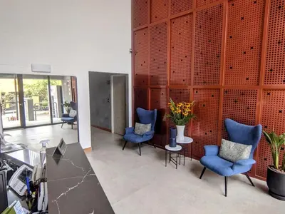 a lobby with blue chairs and a table with flowers at Stay, explore and enjoy Lima in Lima