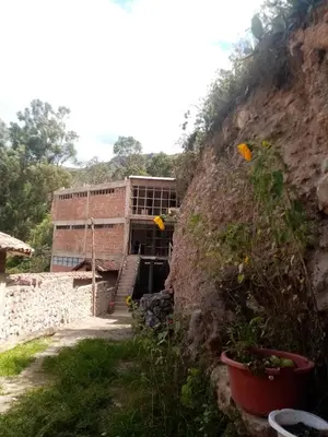 a building on the side of a mountain at Hostal Aylluq Wasin - Guest House-Casa de Familia in Urubamba