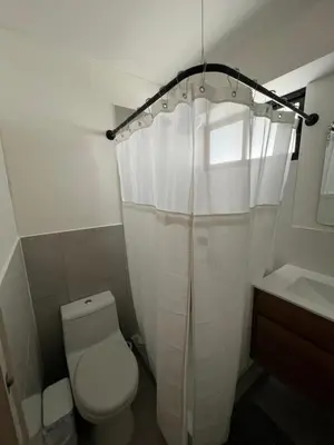 a bathroom with a toilet and a white shower curtain at Relajar y trabajar en Miraflores in Lima