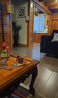 a living room with a table and a couch at La Cabaña de Mary in Oxapampa