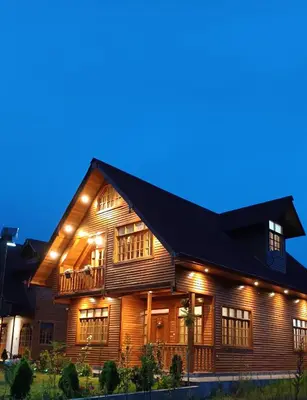 a wooden house with a black roof at night at La Cabaña de Mary in Oxapampa