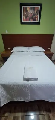a large white bed with a white towel on it at HsDverdi in Santa María