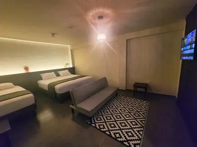 a hotel room with two beds and a television at China Chancay Hotel in Chancay