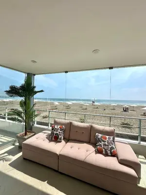 a living room with a couch in front of a beach at Casa de Playa con vista panorámica in Islote Los Leones