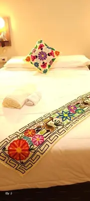 a hotel room with two beds with flowers on them at Oasis Inka Machupicchu in Machu Picchu