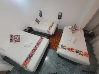 two beds in a small room with flowers on them at Oasis Inka Machupicchu in Machu Picchu