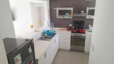a small kitchen with a sink and a stove at Asia - Condominio Las Terrazas - departamento lindo y confortable in Islote Los Leones