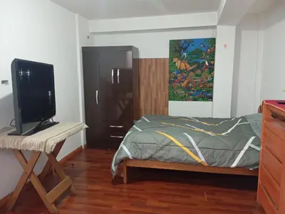 a bedroom with a bed and a desk with a television at Estancia Concepción Cusco - Peru in Cusco