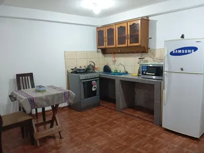 a kitchen with a white refrigerator and a table at Estancia Concepción Cusco - Peru in Cusco