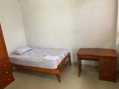 a small bedroom with a bed and a table at Casa de campo en Chincha in Chincha