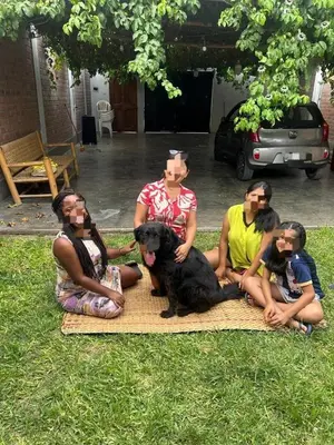 a group of people sitting on a blanket with a dog at Casa de campo en Chincha in Chincha