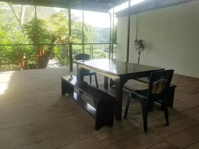 a wooden table and chairs in a room with a balcony at Casa Hospedaje terraza con vista a La Merced in La Merced