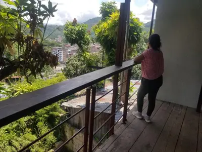a woman standing on a balcony looking out at the city at Casa Hospedaje terraza con vista a La Merced in La Merced