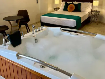a bath tub filled with water in a room with a bed at Hotel Limamar in Lima