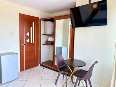 a dining room with a table and chairs and a tv at Hotel Limamar in Lima