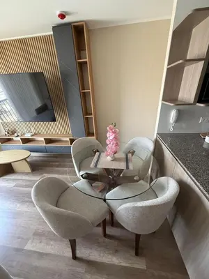 a living room with chairs and a table and a kitchen at Apartment in La Victoria in Lima