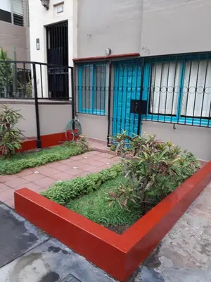 a building with a red planter in front of it at Groundfloor, onebedroom apartment in Lima