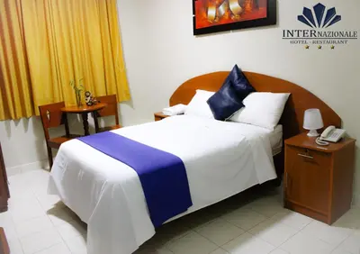 a bedroom with a bed with a telephone and a table at Hotel INTERnazionale in Ayacucho