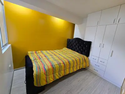a bedroom with a bed with a yellow wall at 401 Moderno departamento equipado in Abancay