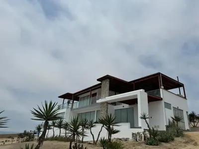 a house on the beach with palm trees at Casa de campo con vista al mar in Punta Negra