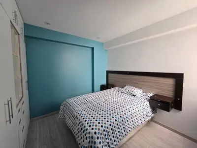 a bedroom with a bed and a blue wall at 402 Moderno departamento equipado in Abancay
