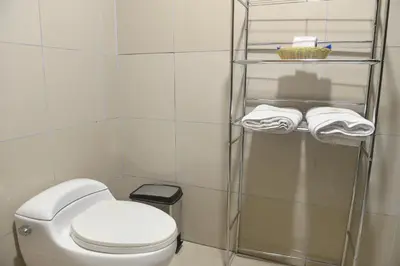 a bathroom with a white toilet and towels at Hotel Lima City in Lima