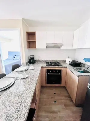 a kitchen with white cabinets and a marble counter top at The Pool & City Spot - steps from Miraflores in Lima